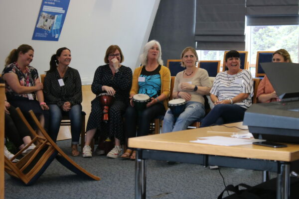 A Group Of Female Teachers Sit In A Row Learning